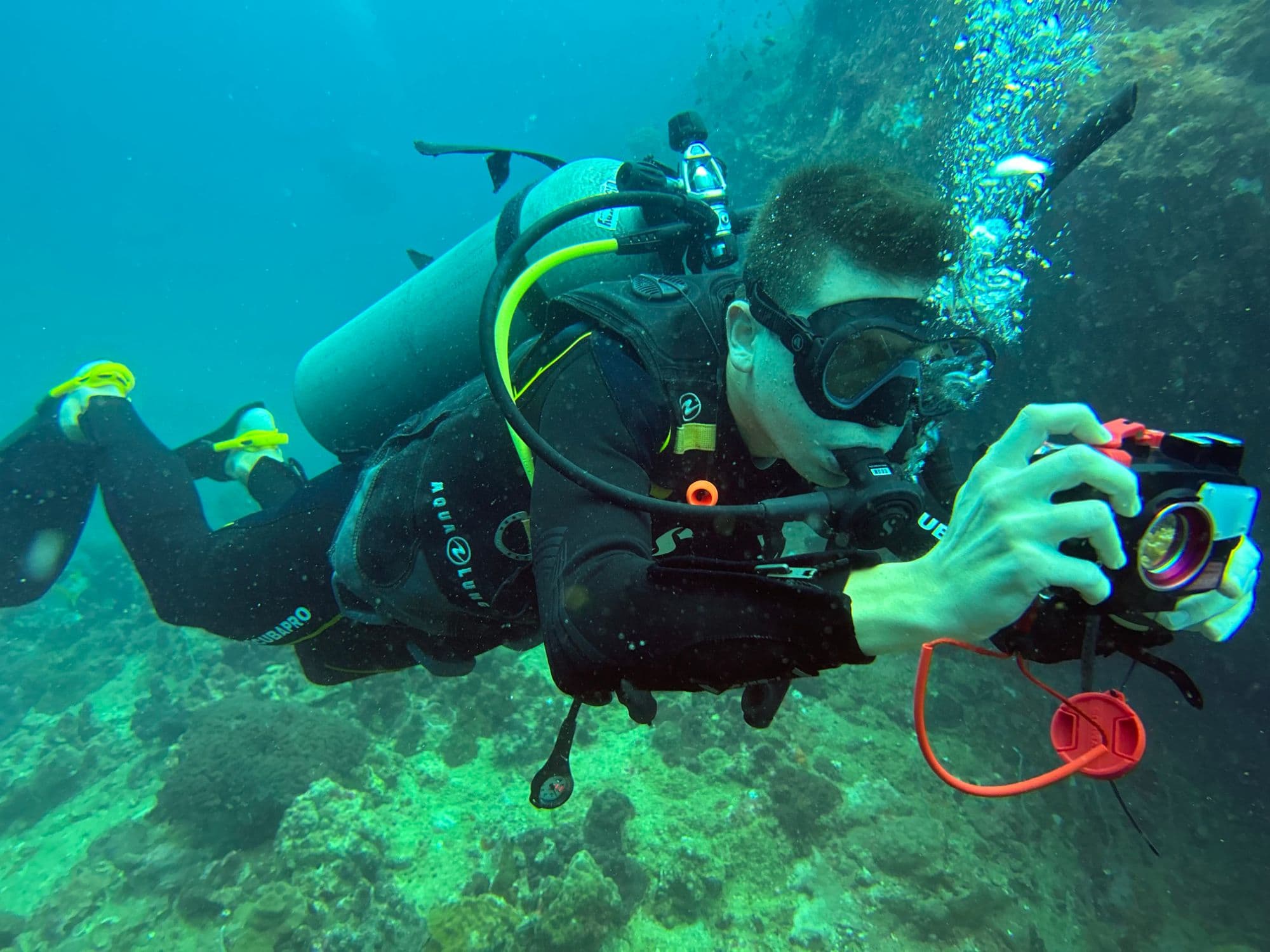 Scuba diver with an underwater camera on a reef in the Gulf of Thailand